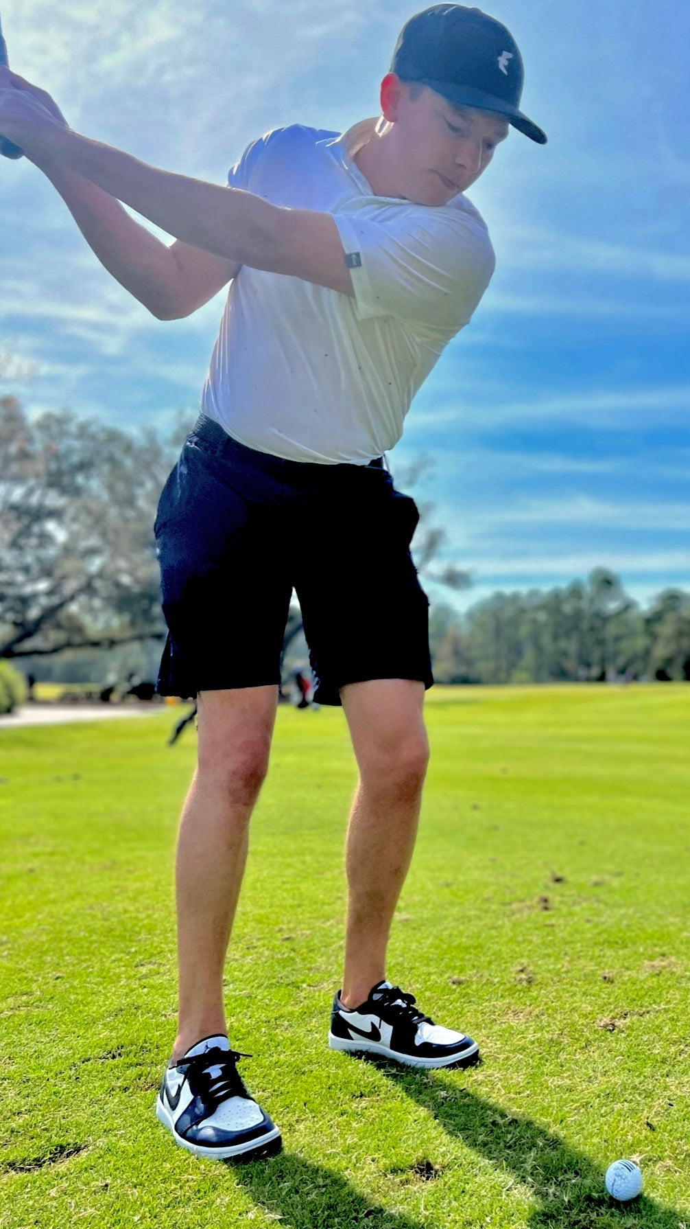 Right handed golfer swinging a golf club in Eagle Apparel Golf Clothing